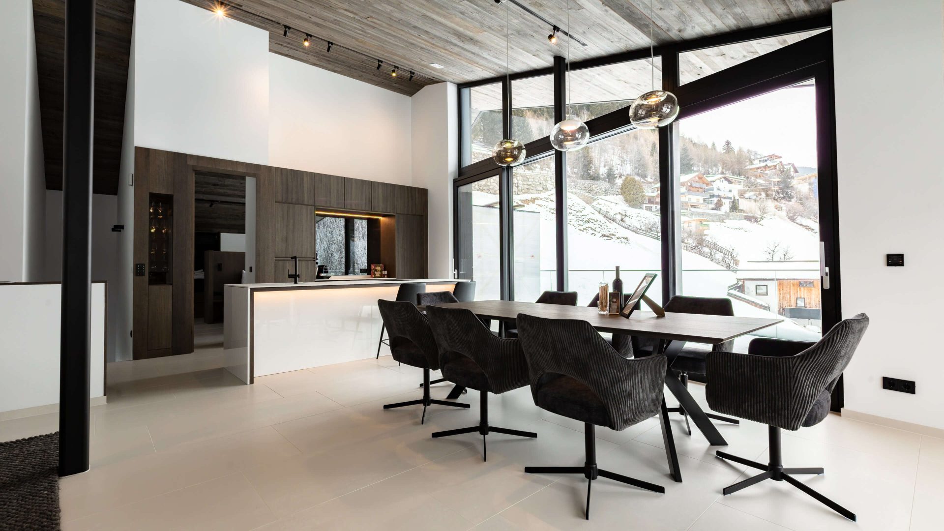 Elegantes Wohnzimmer im Deluxe Penthouse mit großem Esstisch und Panoramafenster.